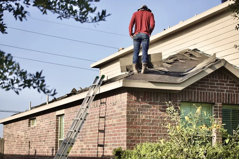 Professional roofer working on a residential roof in Montclare